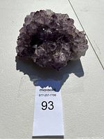 Top view of large purple amethyst crystal cluster showing pointed crystal formations and speckled inclusions within the crystals.