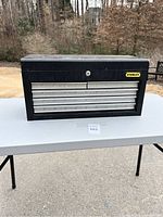 Front view of the Stanley metal tool chest showing three drawers and lock