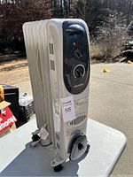 Side view of white oil-filled space heater on wheels showing vented fins and front control panel.