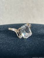 Front angle view showing emerald-cut center stone and setting