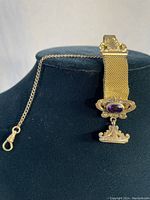 Full view of the antique garment pendant pocket watch clip with attached mesh strap on black display form.