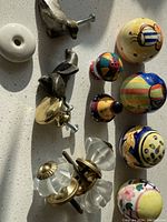 Overview of assorted decorative handles on white surface with shadows.