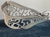 Close-up photo of the vintage sterling silver monogram pin showing detailed filigree and monogram design.