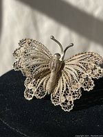 Close-up view of the vintage sterling silver filigree butterfly brooch showing intricate design and texture.