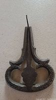 Front view of the antique jaws harp showing ornate heart-shaped design and patina on metal surface.