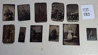 Photo showing 11 various antique tin type and glass photographs of men, women, and children in period attire, mostly seated or posing formally.
