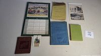 Photo of assorted vintage books, booklet, pamphlets, and a small saint card together with a Barriefield Village calendar 1953.