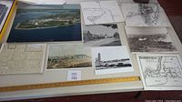 Overview of various maps and photographic prints laid out on table