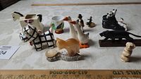 Overview of the collection of small animal and novelty ceramic figurines including Shawnee 660 cow planter and assorted small animal figures