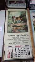 1940 calendar showing girl and dog by pond with January month grid and advertising from The Ontario Paint & Varnish Co.