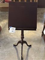 Full view of the cherry wood lectern music stand showing the top platform and tripod base.