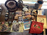 Image showing a variety of items including painted agate stones, National Park postcards, rocks, wooden carvings, and a ceramic vase.