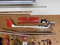 Full view of plane glider showing body, wings, tailfin, rudder with accessories on pegboard