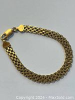 Full view of multi-strand gold bracelet laid flat