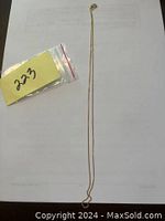 Full length of 16-inch chain laid flat with lot tag