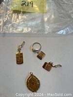 All five items laid out: rectangular and square RBC pendants, ring, religious medallion