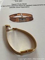 Watch laid flat showing rectangular cream dial and mesh bracelet