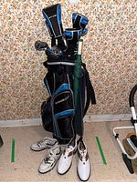 Full view of Adams Golf bag with clubs, umbrella and two pairs of shoes