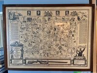 Large framed historic map with detailed illustrated border and historic figures