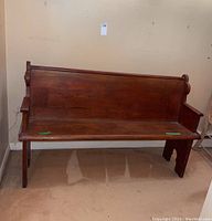 Full front view of wooden bench showing panel back and seat