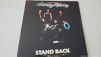 Front cover of April Wine Stand Back vinyl LP album showing the band members and the album title