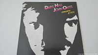 Front cover of the Hall & Oates Private Eyes vinyl record album showing stylized faces and album title.