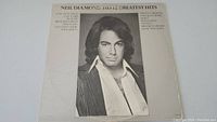 Front cover of Neil Diamond His 12 Greatest Hits album featuring a black and white portrait on white background.