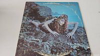 Front cover of Roxy Music Siren vinyl album showing woman on rocks with wear marks on edges.