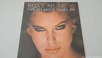 Front cover of Roxy Music The Atlantic Years 1973-1980 vinyl record album showing close-up face portrait of woman with makeup.