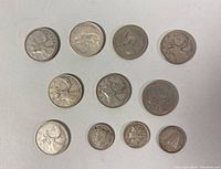 Top view of all 11 coins including Canadian quarters and US dimes.