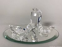 Clear crystal Swarovski king cobra snake figurine with black eyes on a round beveled mirrored base.