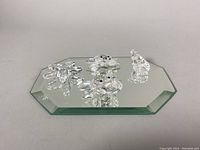 Four Swarovski crystal sea creature figurines on a beveled mirrored base showing starfish, two crabs, and a seashell.