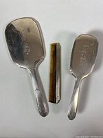 Top view of the 3-piece vanity set showing mirror, comb, and brush laid flat.