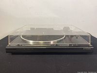 Front view of Pioneer PL-570 turntable with clear dust cover on, showing overall condition and design.