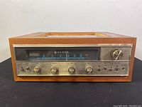 Front view showing wood casing and control panel with tuning needle, knobs, and switches.