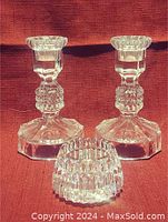 Photo of three cut crystal candle holders: two tall candlesticks with broad bases and one shorter round candle holder.
