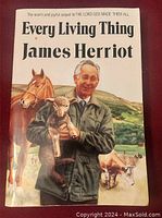 Front cover of Every Living Thing large print book showing James Herriot holding a lamb with other farm animals in the background