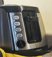Close-up of the toaster control panel showing the buttons for Keep Warm, Bagel, Defrost, and Cancel, along with a numbered dial for toasting levels.