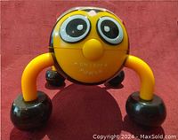 Front view close-up of bee massager showing face with on/off power switch and legs with massage heads