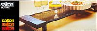 Photo of Salton Hot Tray packaging showing the product in use on a table with plates and glasses.