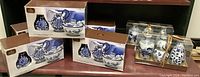 Photo showing boxed creamer and sugar bowl sets with blue floral designs.