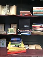 Shelf display of numerous vintage books in assorted sizes, colors, and conditions.