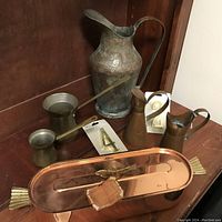 Photo showing all items including large copper pitcher, two metal drink cups, two brass pitchers, copper fish pan, house number 4 and 6 packaging.