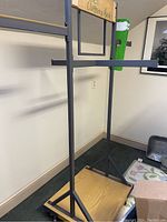 Front view of the clothing rack showing the base shelf, metal frame, and hanging bars.