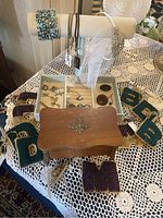 Photo of the wooden jewelry box, embroidered letter patches, and jewelry display stand with bracelets.