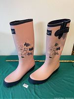 Pair of tall pink ladies Radley wellies with black soles and decorative Radley dog prints on sides, shown side by side.