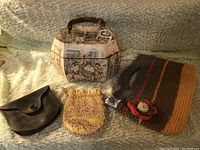 Photo of the four vintage purses arranged: Victorian purse with handle, yellow beaded purse, brown leather wallet, and knitted purse with flower detail.