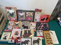 Photo showing a variety of Scottie Dog-themed paper stationery including greeting cards, notepads, gift bags, and stickers arranged on a table.