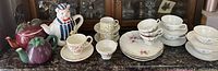 View of all teapots and the tea cup and saucer sets showing patterns and shapes