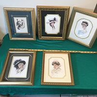 Front view of all five framed Victorian ladies prints laid on a green surface with measuring tape.